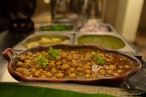 Un plato de garbanzos adornado con hierbas, servido en un cuenco de barro tradicional.