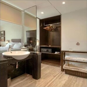 Bathroom features a large mirror above a sink, a shelving unit, and a wooden vanity with a countertop.