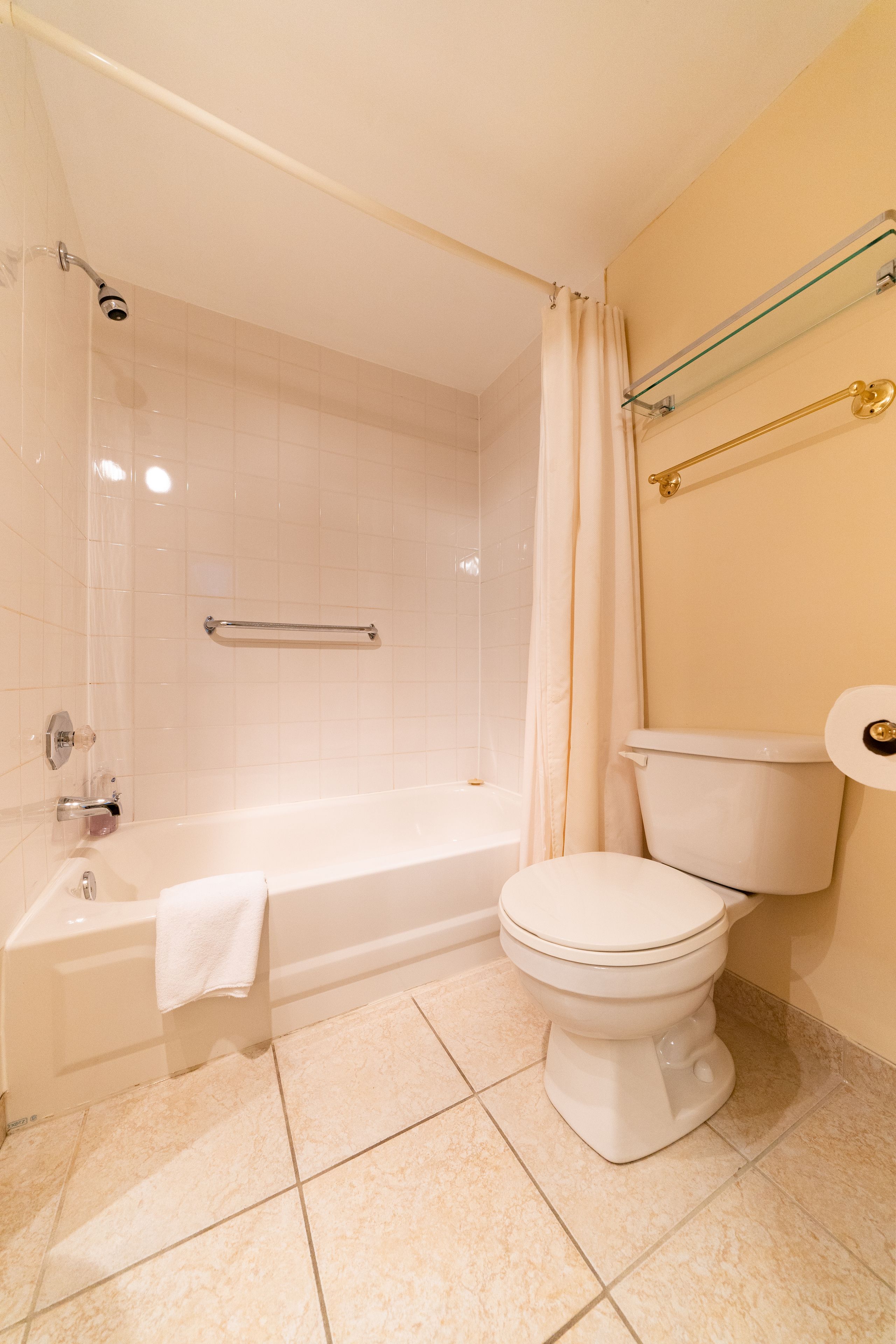 Un baño con bañera, inodoro y cabina de ducha de vidrio.
