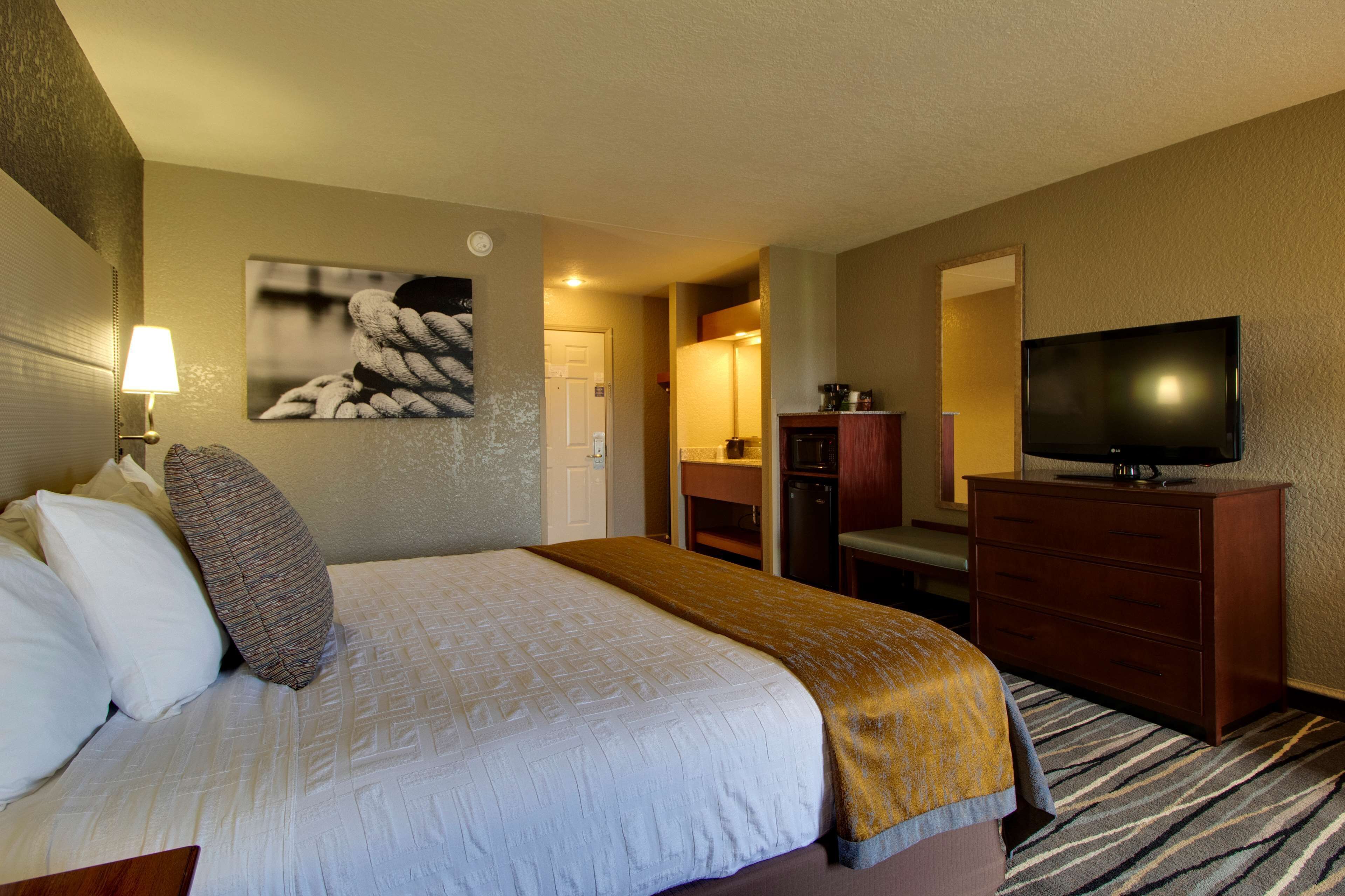 Hotelkamer met een groot bed, een televisie, een dressoir en een badkamer, zichtbaar door een open deur.
