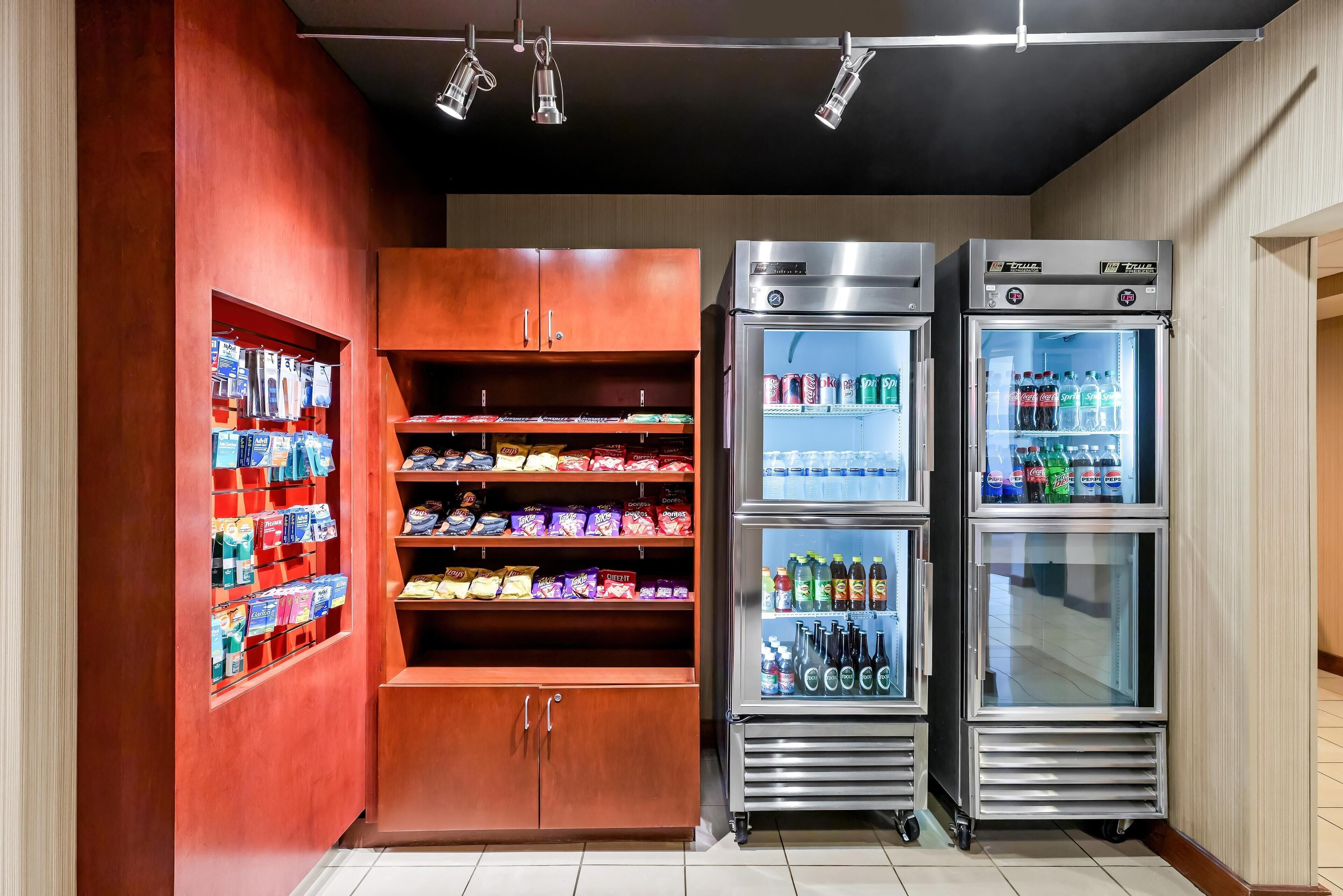 A vending area with snack and drink options, including a refrigerated section with beverages and a shelf with packaged snacks.