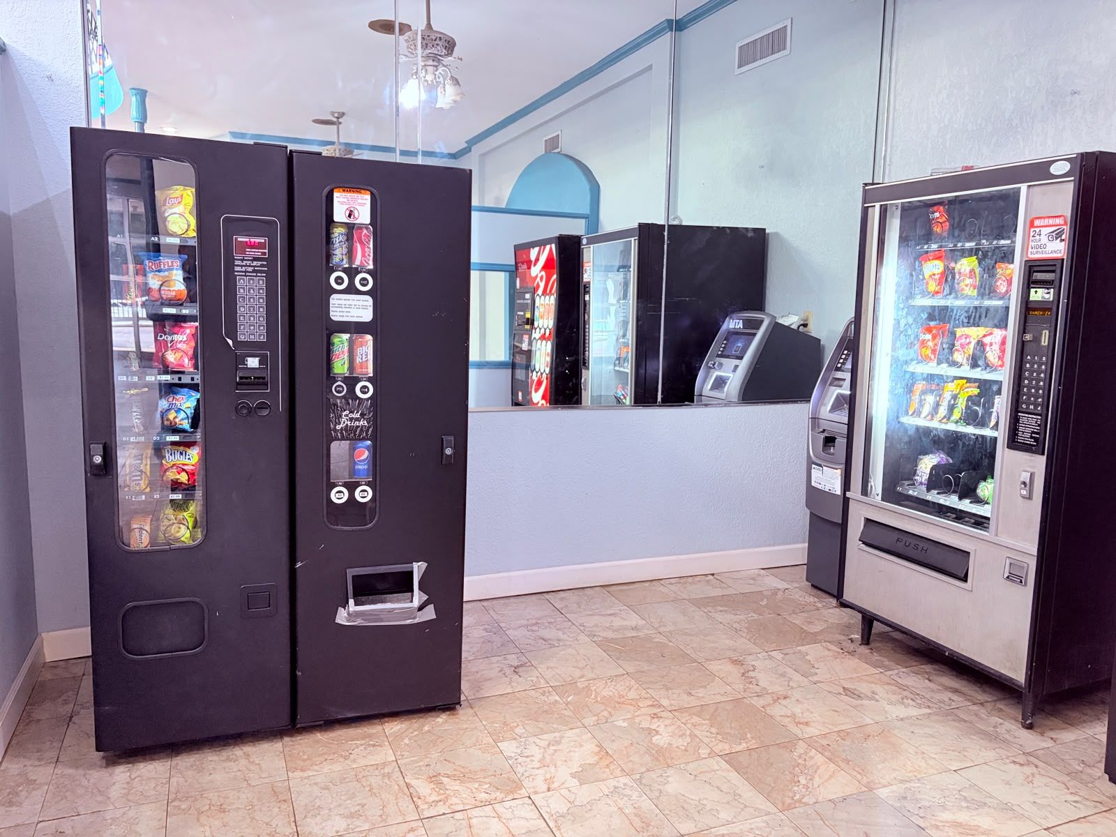 A room with vending machines, a counter, and a ceiling fan.