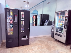 A room with vending machines, a counter, and a ceiling fan.