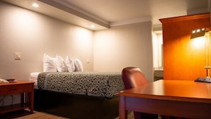 A hotel room with a bed, a desk, and a chair. - Days Inn by Wyndham Hillsboro TX (Hillsboro)