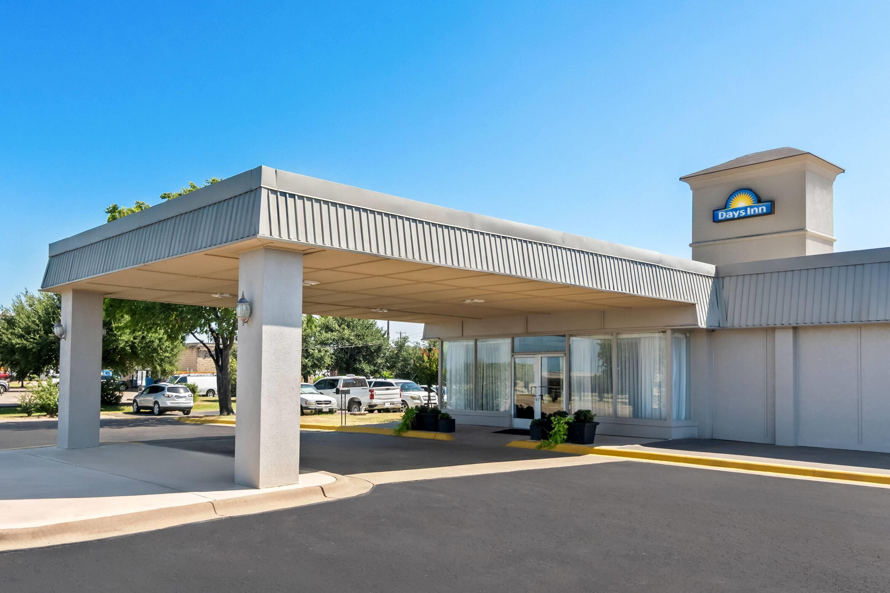 A Days Inn with a covered parking area and a clear sky.