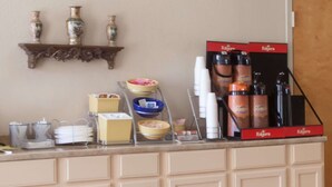 A kitchenette with a coffee machine, cups, and condiments. - Days Inn by Wyndham Hillsboro TX (Hillsboro)