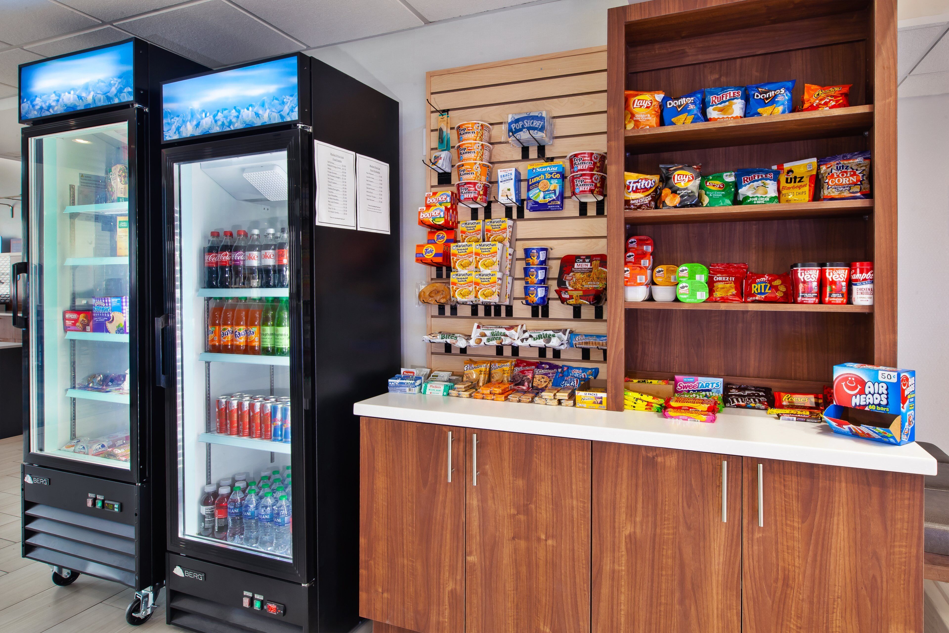 Two beverage dispensers, a snack display, and a counter with various packaged goods.