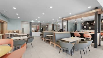 Un interior de restaurante moderno con cabinas, mesas y una zona de bar.