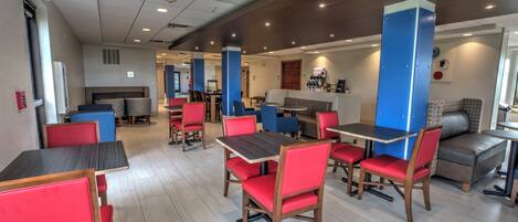 A restaurant with booths and tables, a counter area, and a view of the outside.