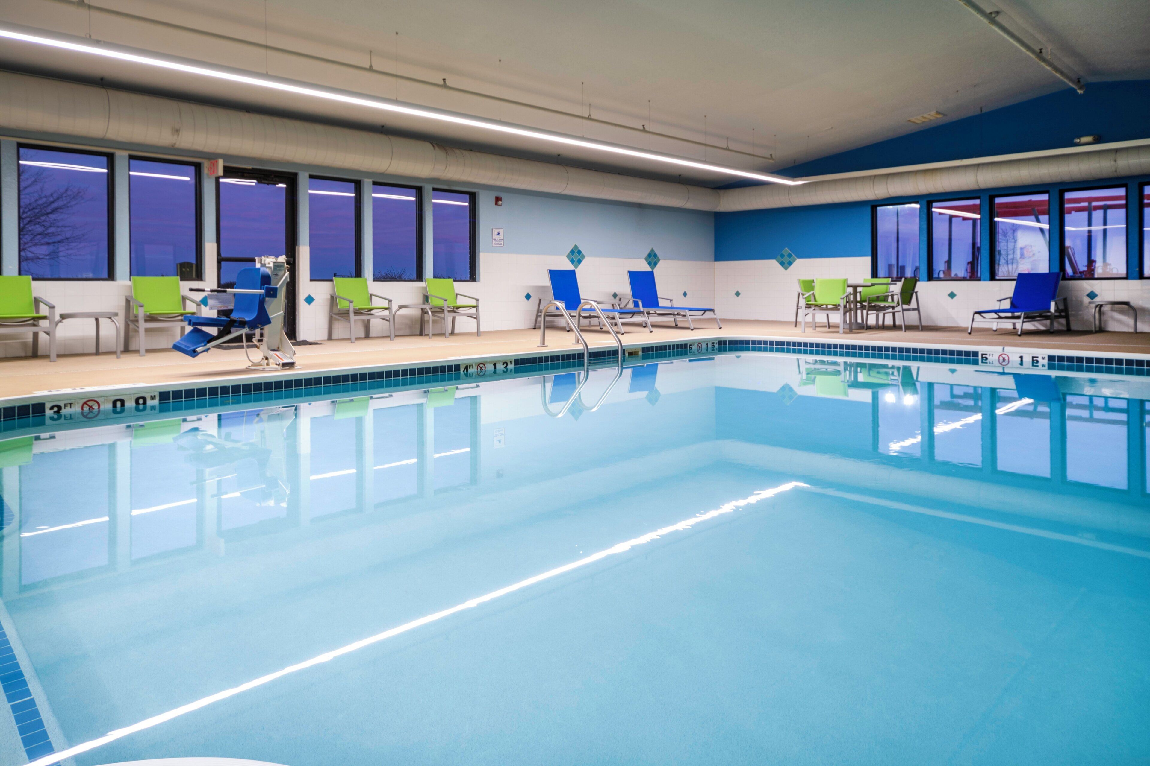 A swimming pool with multiple lounge chairs and a clear blue water surface.