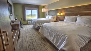 A hotel room with two beds, a desk with a chair, a lamp, and a large window offering a view of the outdoors. - Holiday Inn Express Rochelle by IHG (Rochelle)