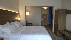 A hotel room with a large bed, a desk, a chair, a wardrobe, and a bathroom visible through an open door. - Holiday Inn Express Rochelle by IHG (Rochelle)