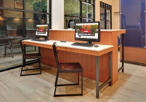 A reception desk with two computer monitors, a wooden counter, and a single chair. - Holiday Inn Express & Suites Austin Round Rock by IHG (Round Rock)