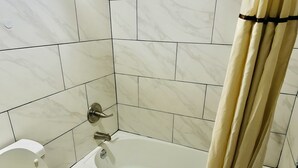 A bathroom with a bathtub, toilet, and a shower curtain. - Travel Inn Bristol near State St (Bristol)