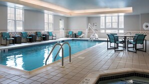An indoor swimming pool with tiled flooring, a pool ladder, and multiple seating areas with chairs. - Residence Inn by Marriott Poughkeepsie (Poughkeepsie)