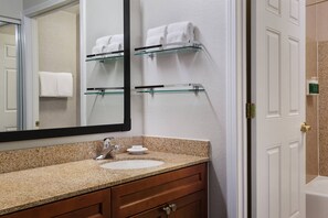 A bathroom with a granite countertop, a white sink, a mirror, and a glass shelf with towels. - Residence Inn by Marriott Poughkeepsie (Poughkeepsie)