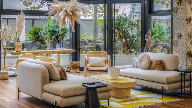A modern living room with a sofa, armchairs, a coffee table, and a dining area with chairs and a table. - Mercure Paris Gare Montparnasse TGV (Paris)