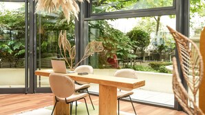 A modern dining area with a wooden table and chairs, a laptop, and decorative plants. - Mercure Paris Gare Montparnasse TGV (Paris)
