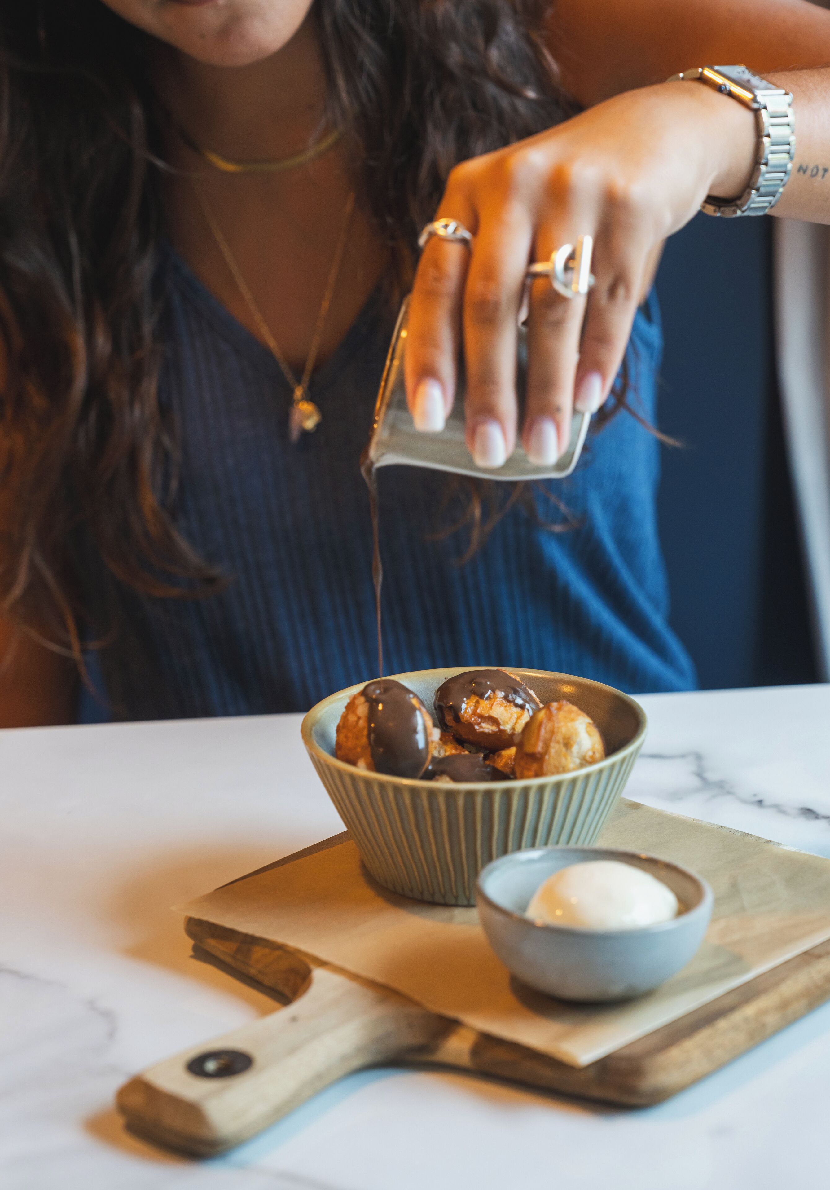 A person pouring a liquid into a bowl of food.