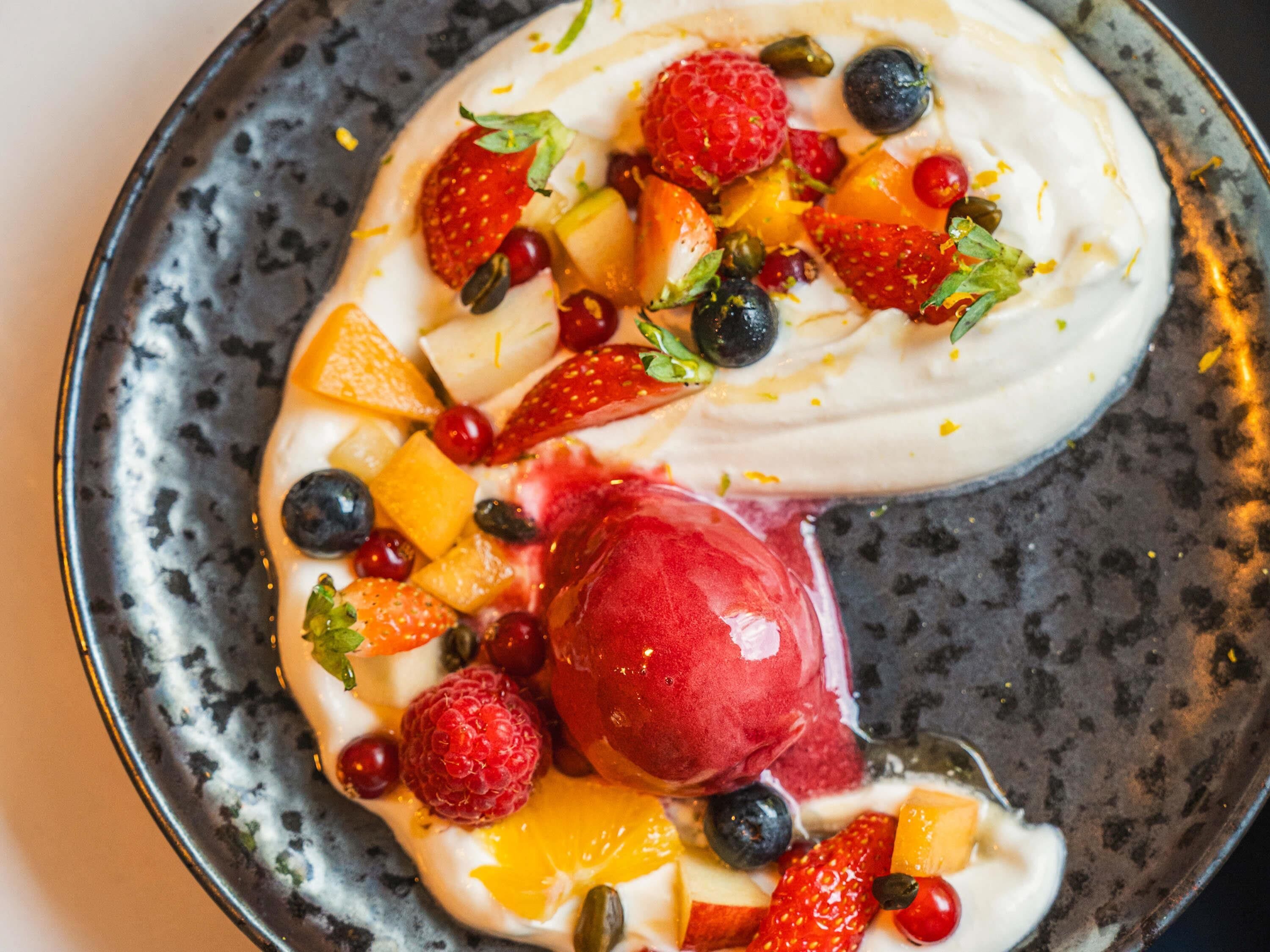 A dessert with fruit and cream on a plate.