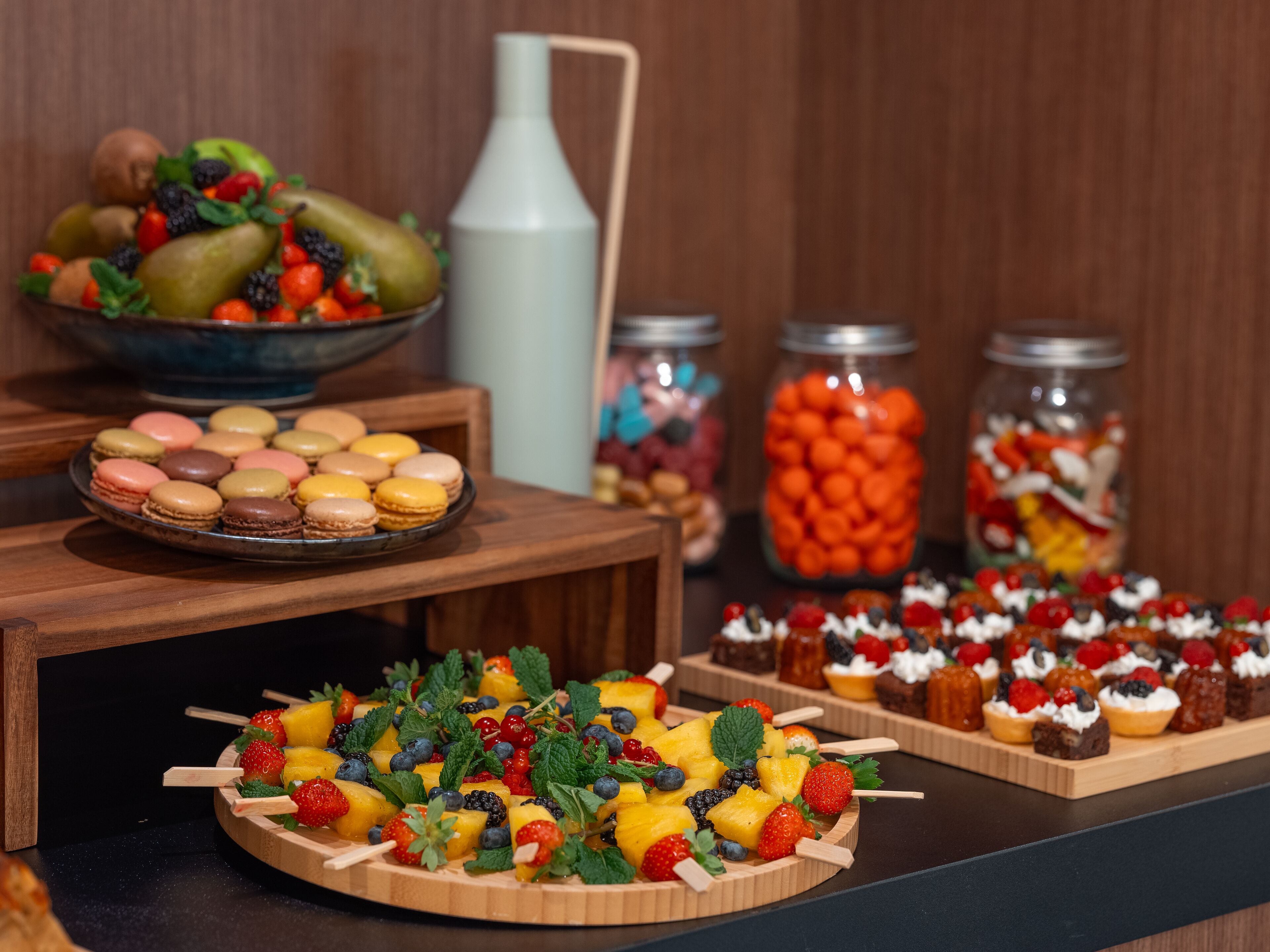 Een buffet met diverse gerechten, zoals fruit, gebak en desserts.
