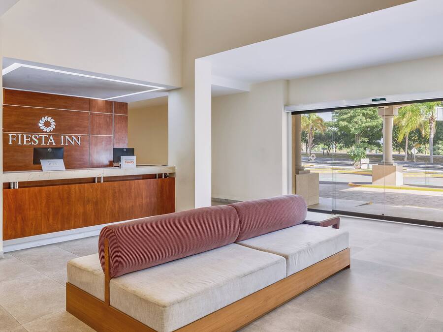 A reception area with a wooden desk, a sofa, and a view of the outside.