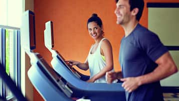 A gym with treadmills and a large mirror.