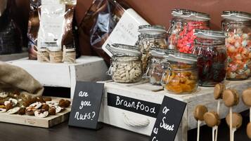A display of various jars containing different types of food items, with signs asking if the viewer considers them nuts or sweet as candy.