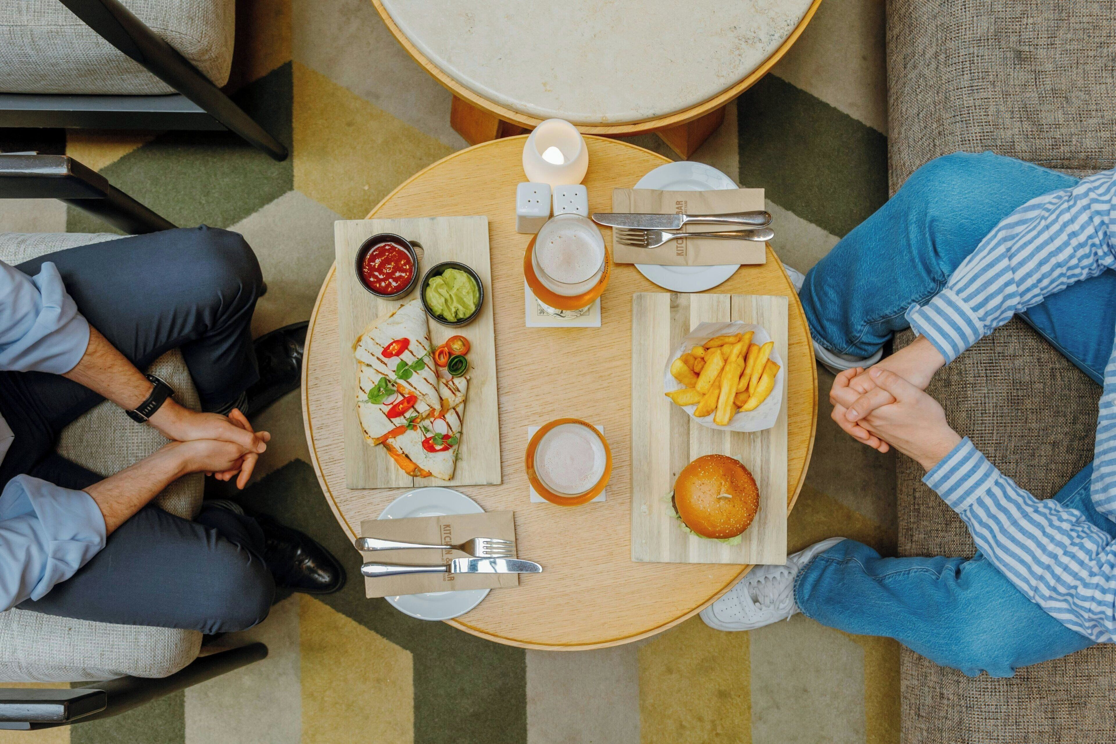 A round dining table with plates of food, cutlery, and condiments.