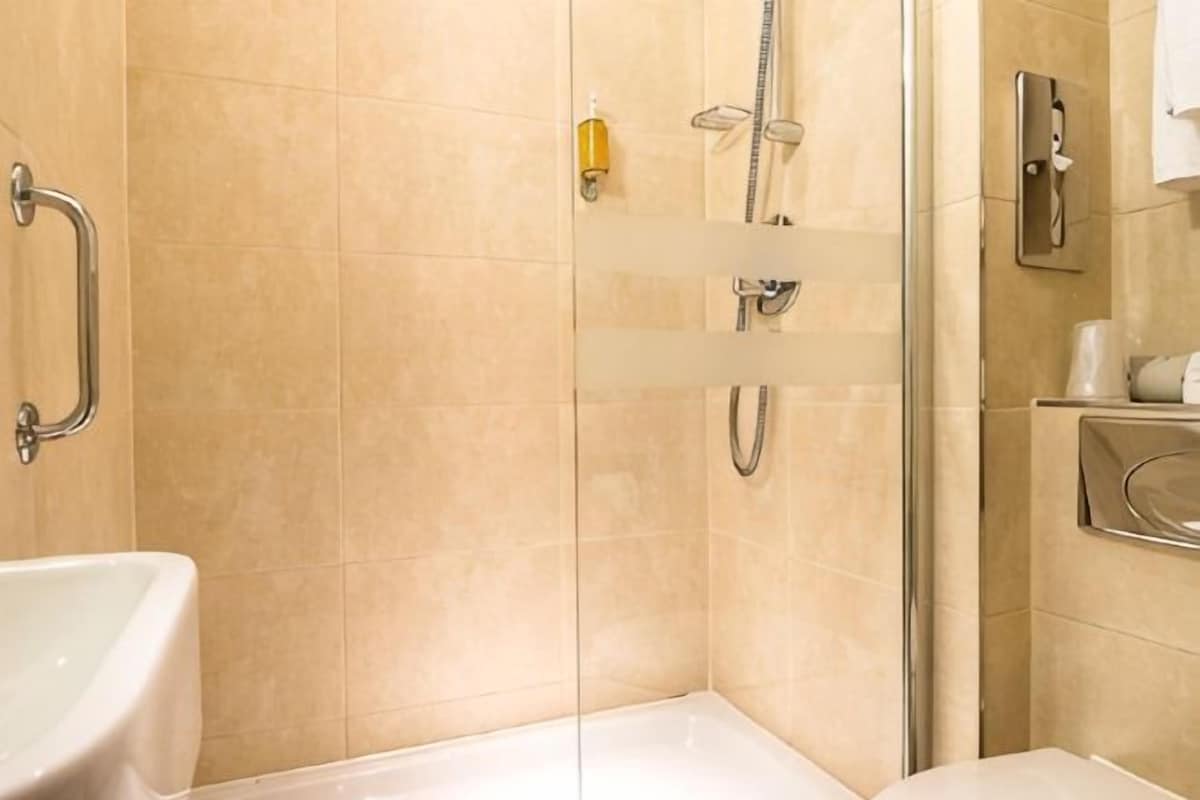 A bathroom with a shower, a toilet, and a sink.