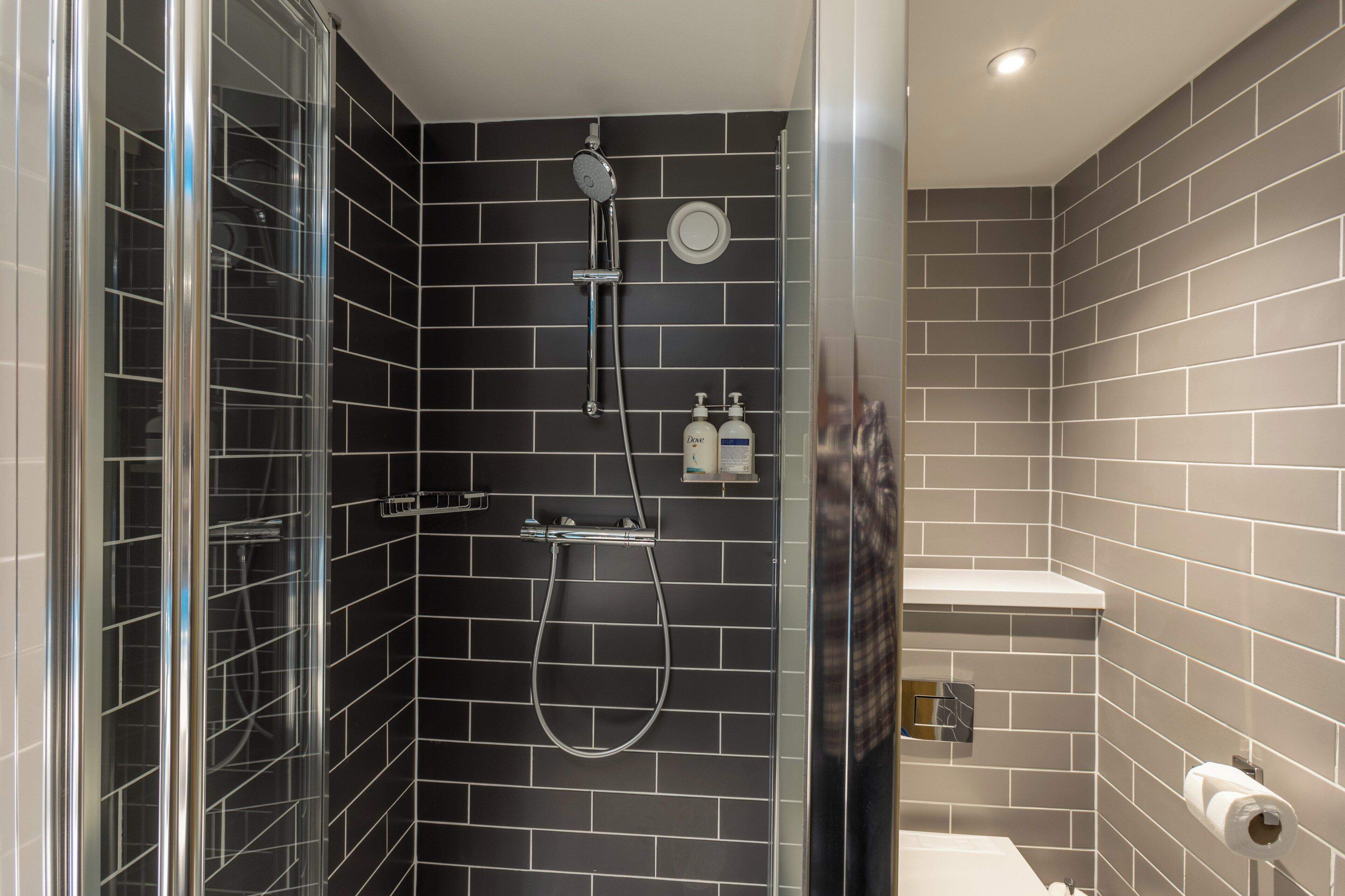 Un baño moderno con ducha, inodoro y lavamanos.