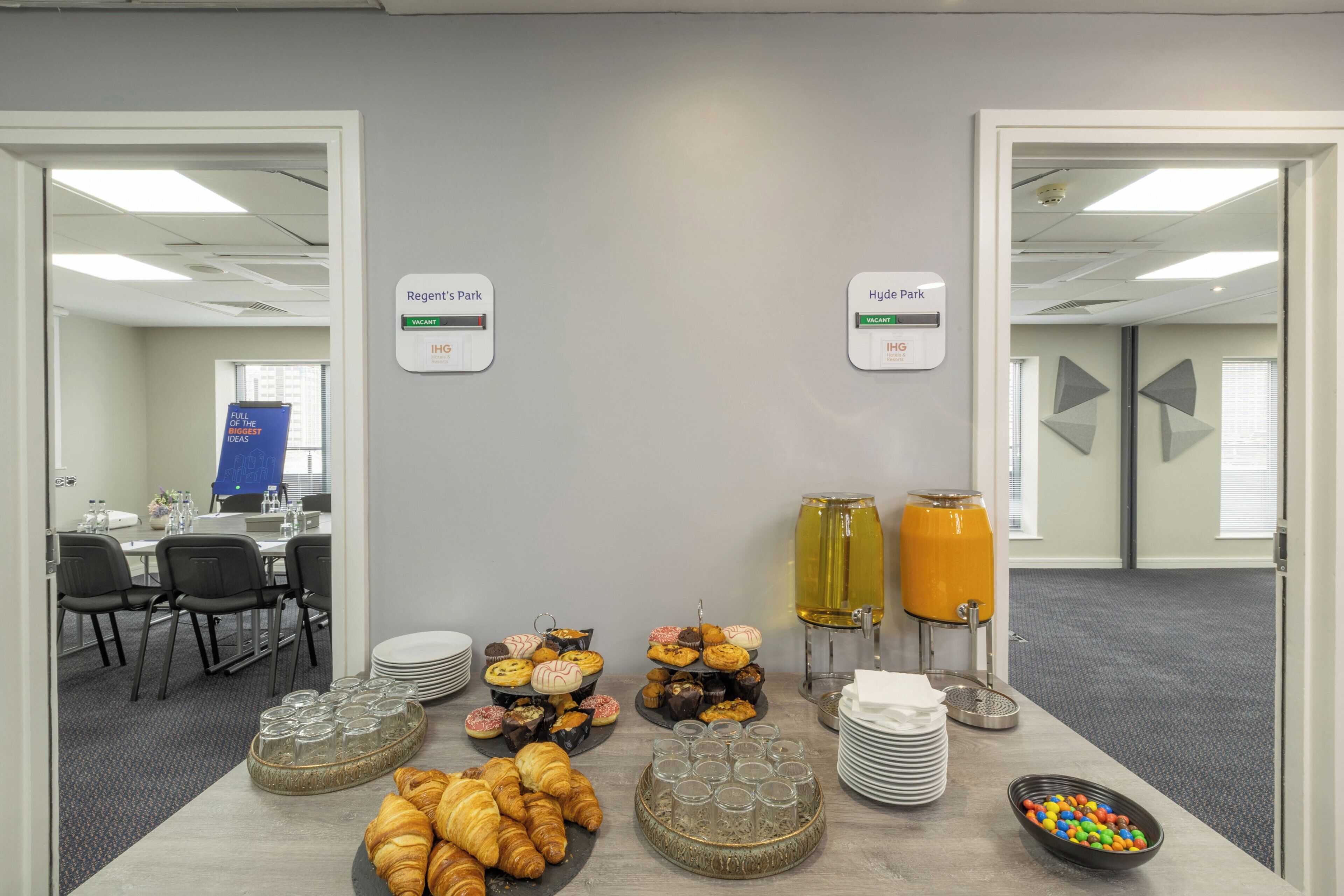 A breakfast buffet with pastries, drinks, and a sign indicating vacant parking spaces.