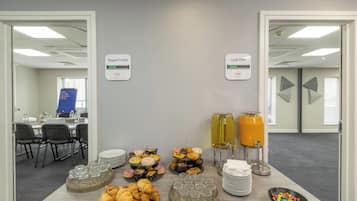 A breakfast buffet with pastries, drinks, and a sign indicating vacant parking spaces.