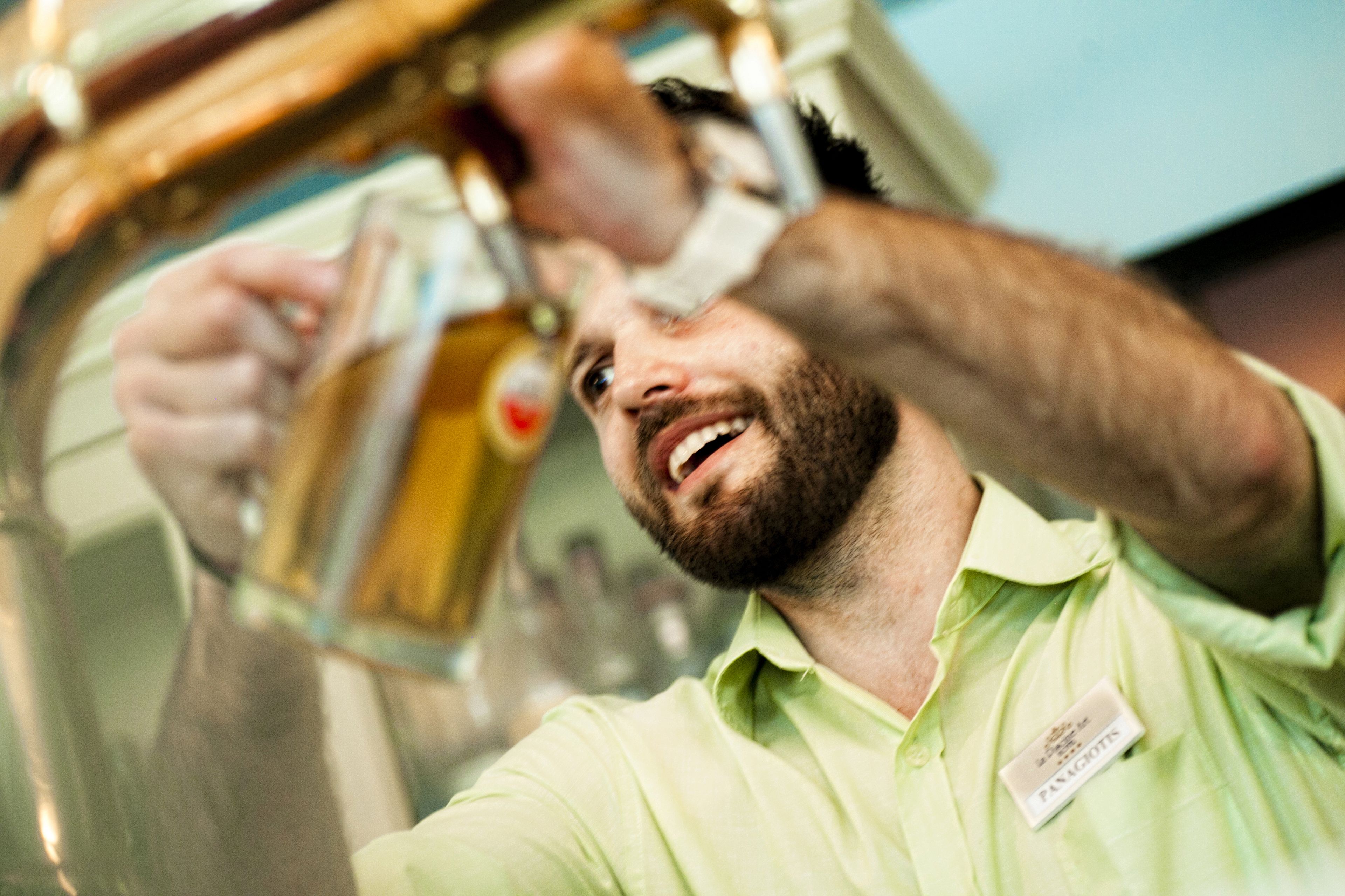 Una persona sirviendo una bebida de una botella.