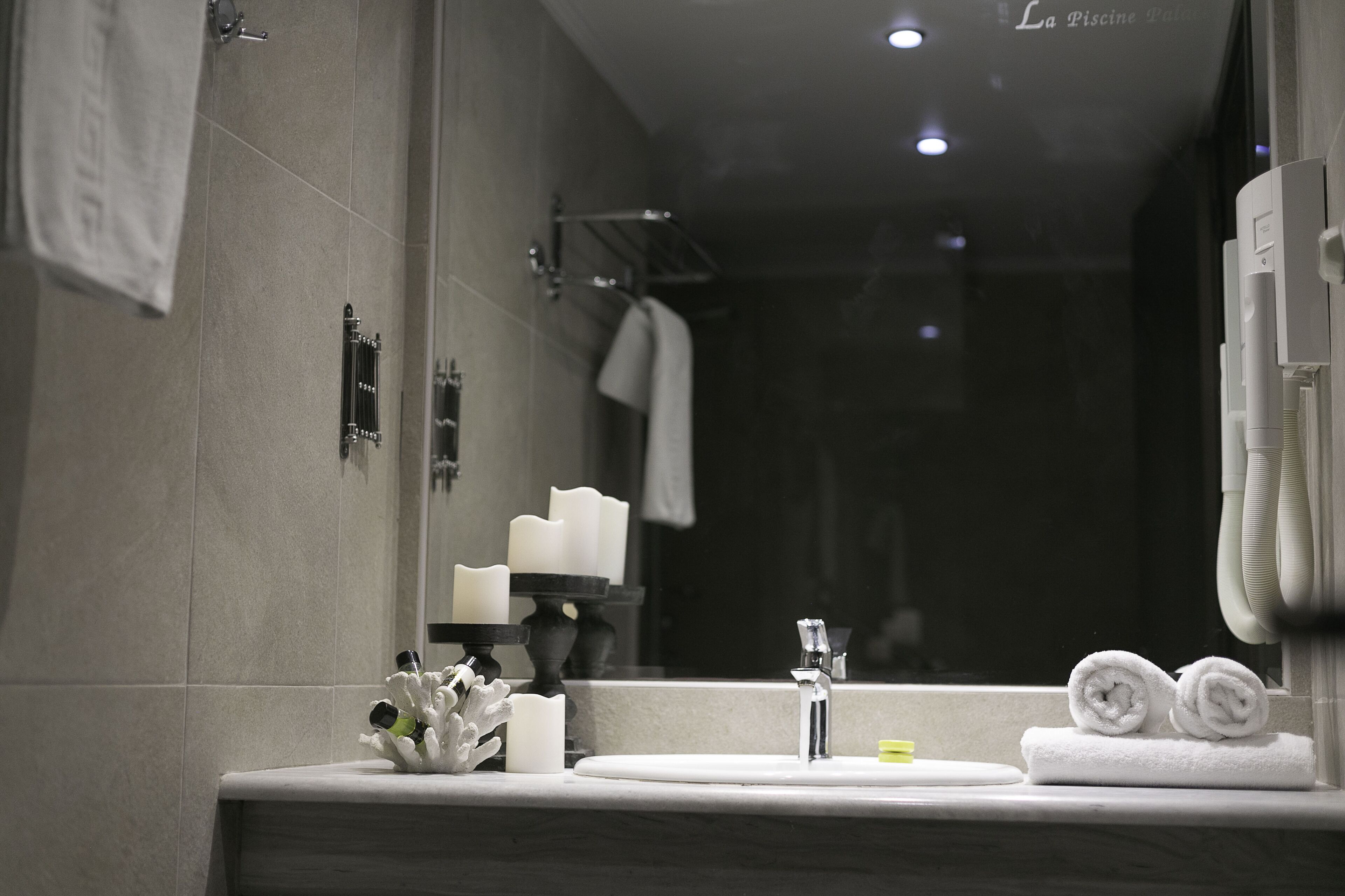 Un baño moderno con lavabo, espejo y toallero.