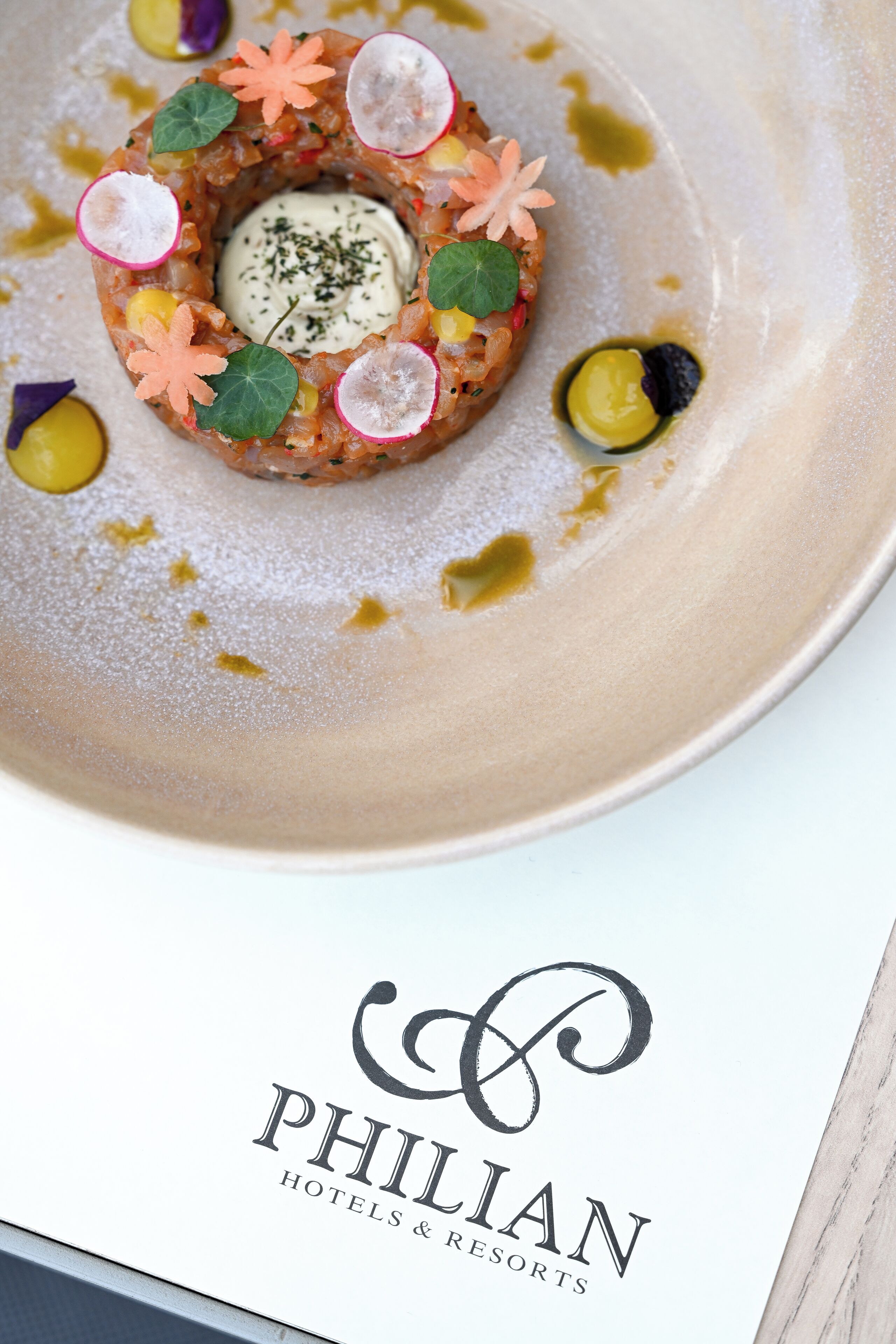 Un postre en un plato con el logotipo de "PHILIAN HOTELS & RESORTS" debajo.