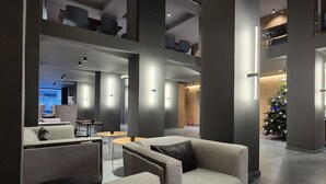 Un hall d'entrée moderne avec des canapés, des tables et un sapin de Noël.
