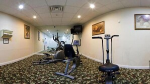 A hotel fitness room with exercise equipment, carpeted floor, and artwork on the walls. - Candlewood Suites St. Joseph / Benton Harbor by IHG (Stevensville)