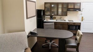 Una cocina compacta con comedor, que incluye una mesa, sillas y un refrigerador.
