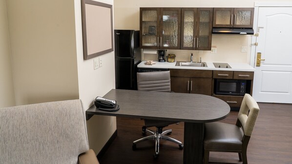 Una cocina compacta con comedor, que incluye una mesa, sillas y un refrigerador.