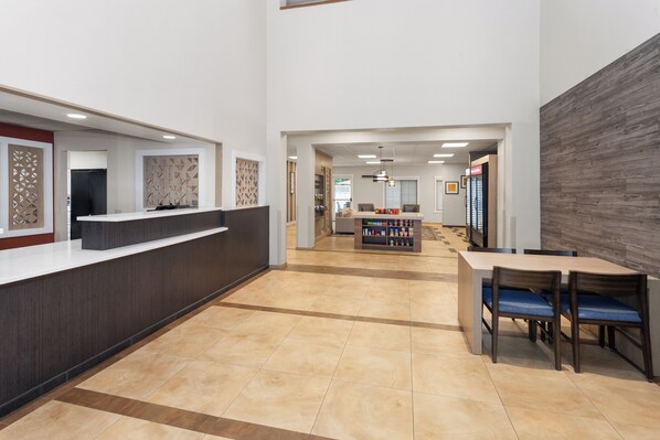 A reception area with a counter, seating area, and a beverage station.
