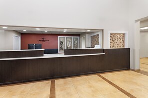 Una recepción con el letrero de Candlewood Suites, un teléfono y un panel decorativo.