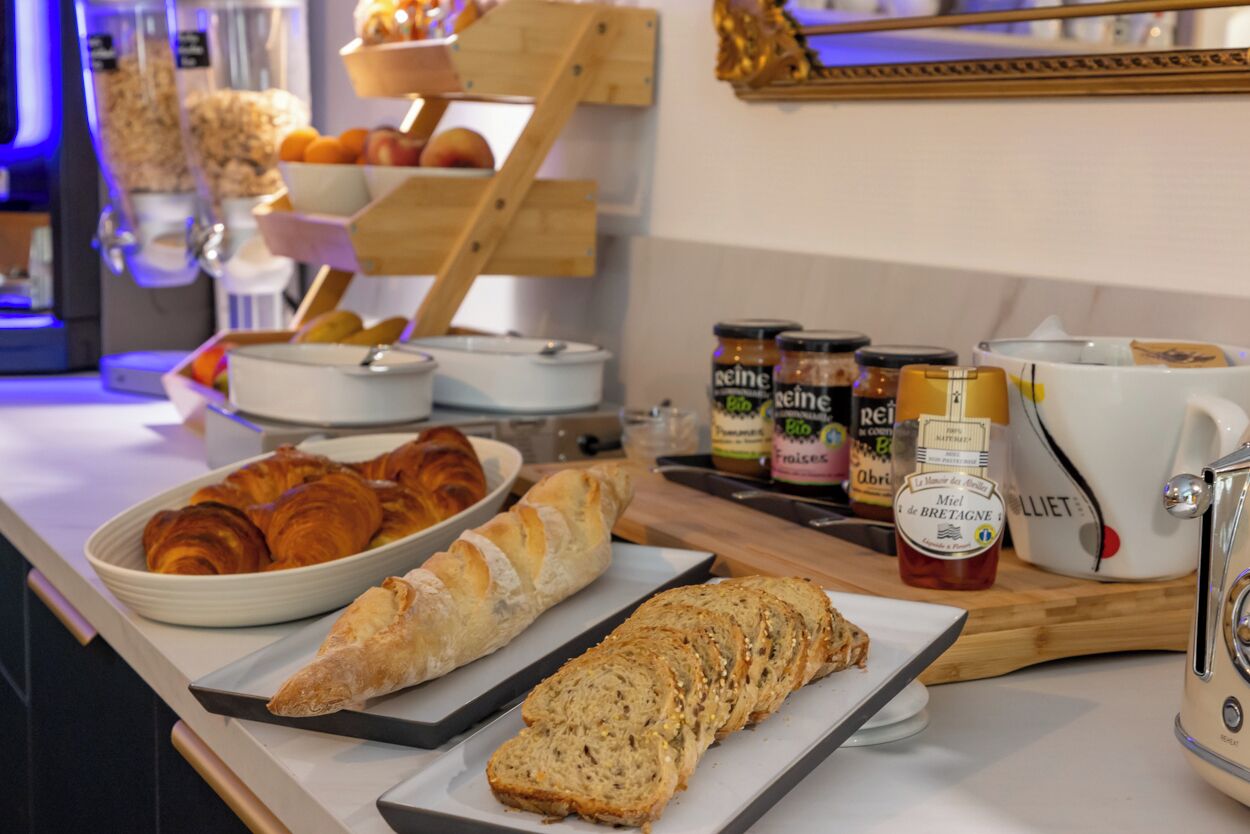 Un bufé de desayuno con cruasanes, pan y mermeladas.