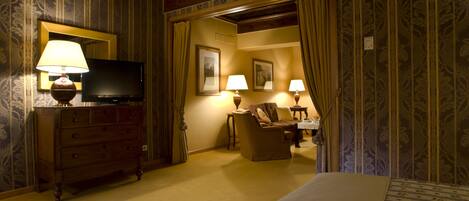 A hotel room with a bed, a dresser, a television, and two lamps.