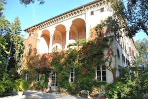 A building with a white facade, multiple arches, and ivy-covered walls. - Villa La Principessa (Lucca)