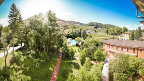 Una villa con un sendero rojo, abundante vegetación y una piscina.