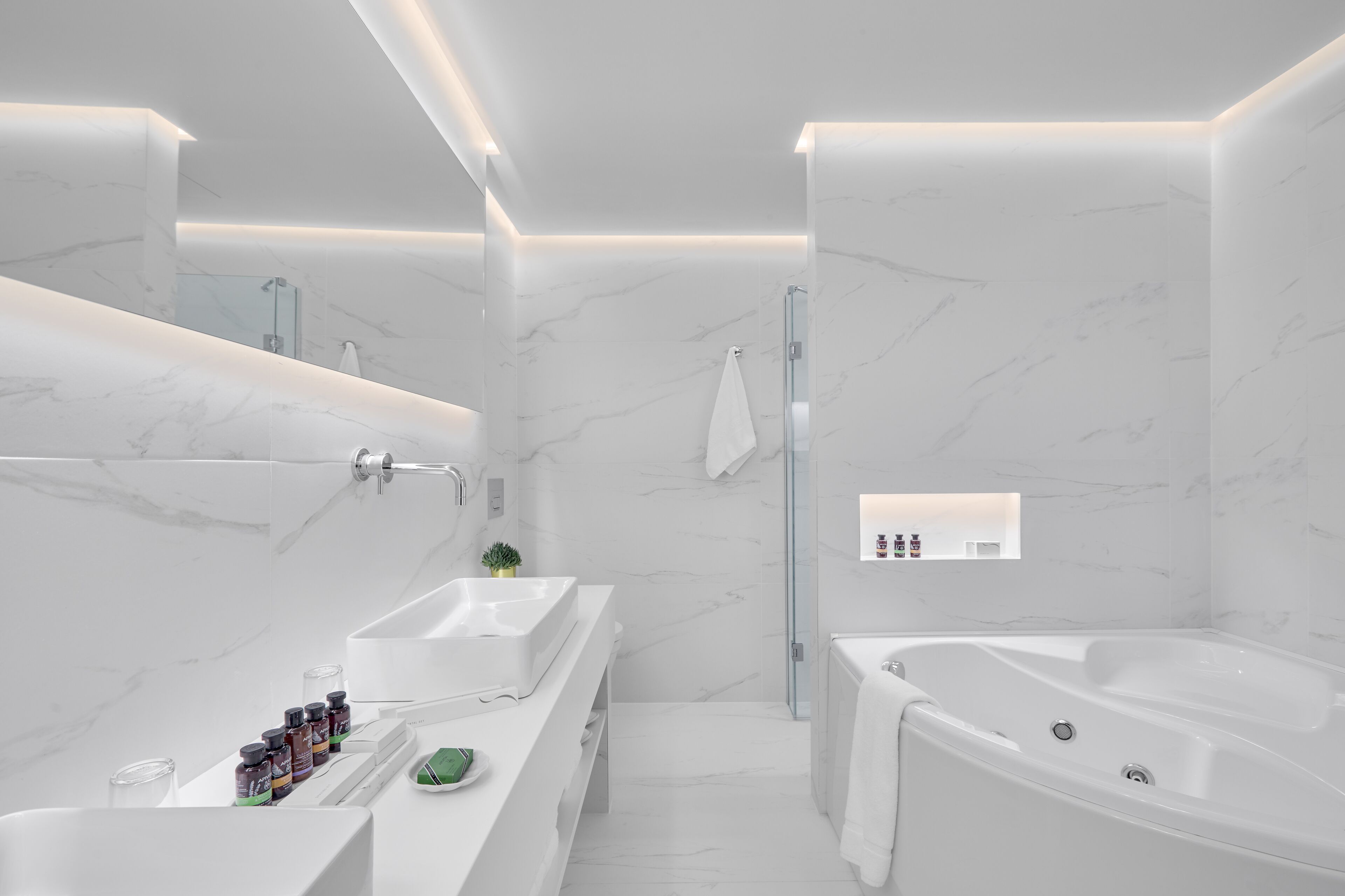 A modern bathroom with a large bathtub, a walk-in shower, and a vanity with a sink and mirror.