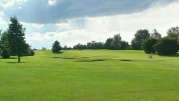 Enjoy a serene golfing experience amidst lush greenery and scenic views.