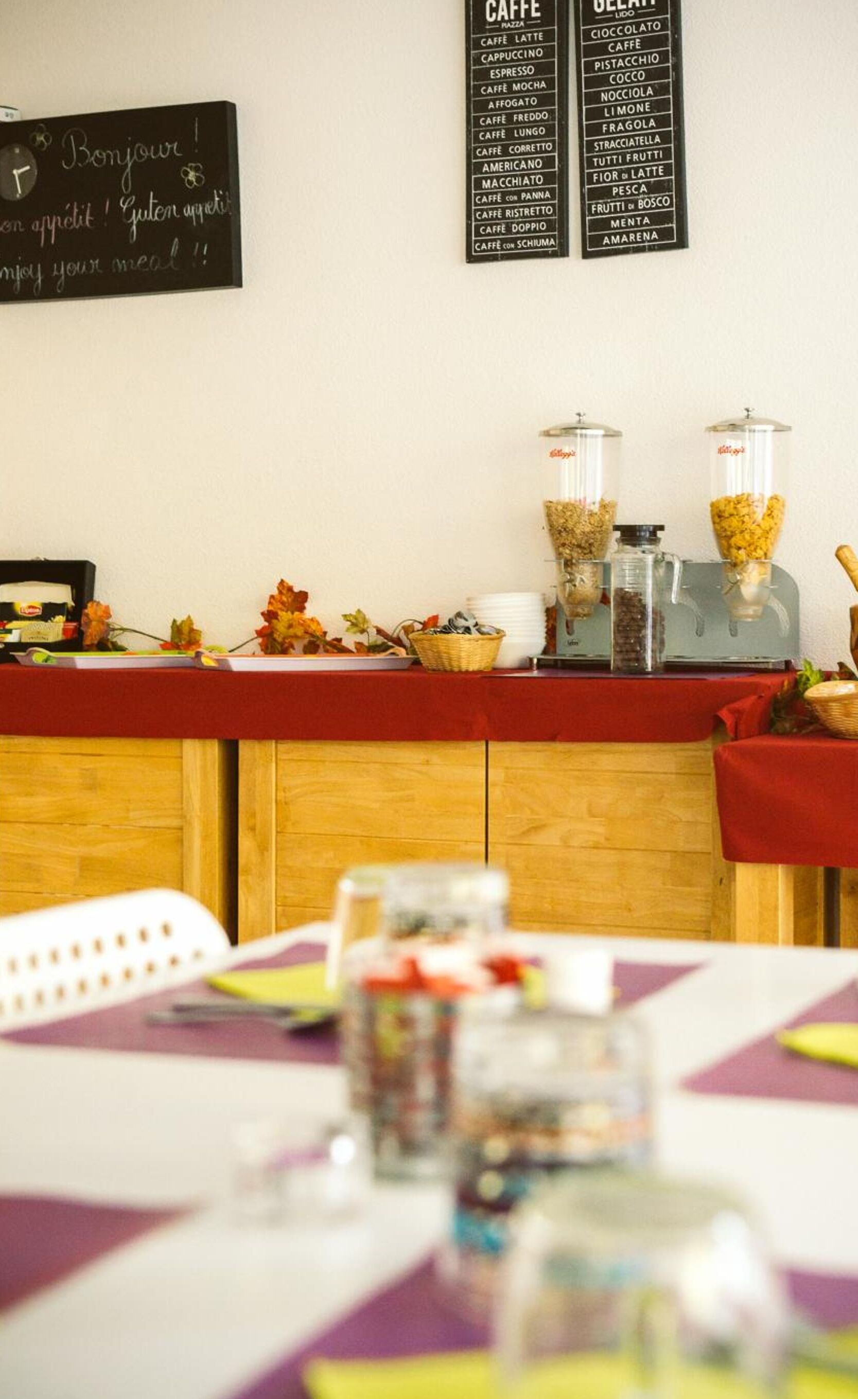 Un comptoir de café avec un tableau noir affichant un menu proposant différents types de café et de plats, une machine à café et un panier de fruits.