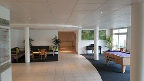 A spacious lobby with a pool table, a piano, and seating areas. - Residence le Royal Golf & Horse (Mooslargue)